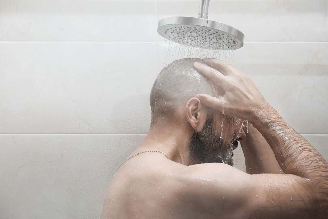 Homme chauve sous a douche